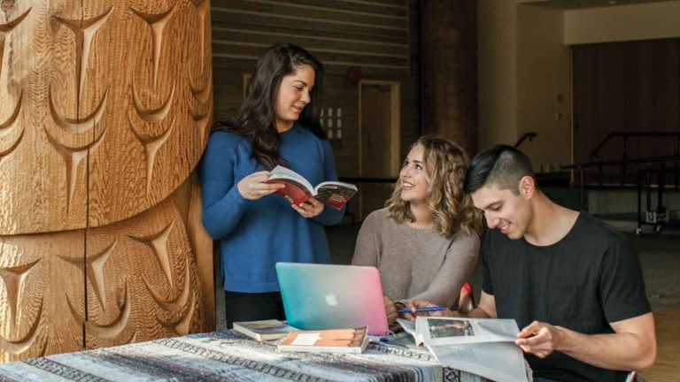 Three students reading books, UBC Aboriginal Student Affairs