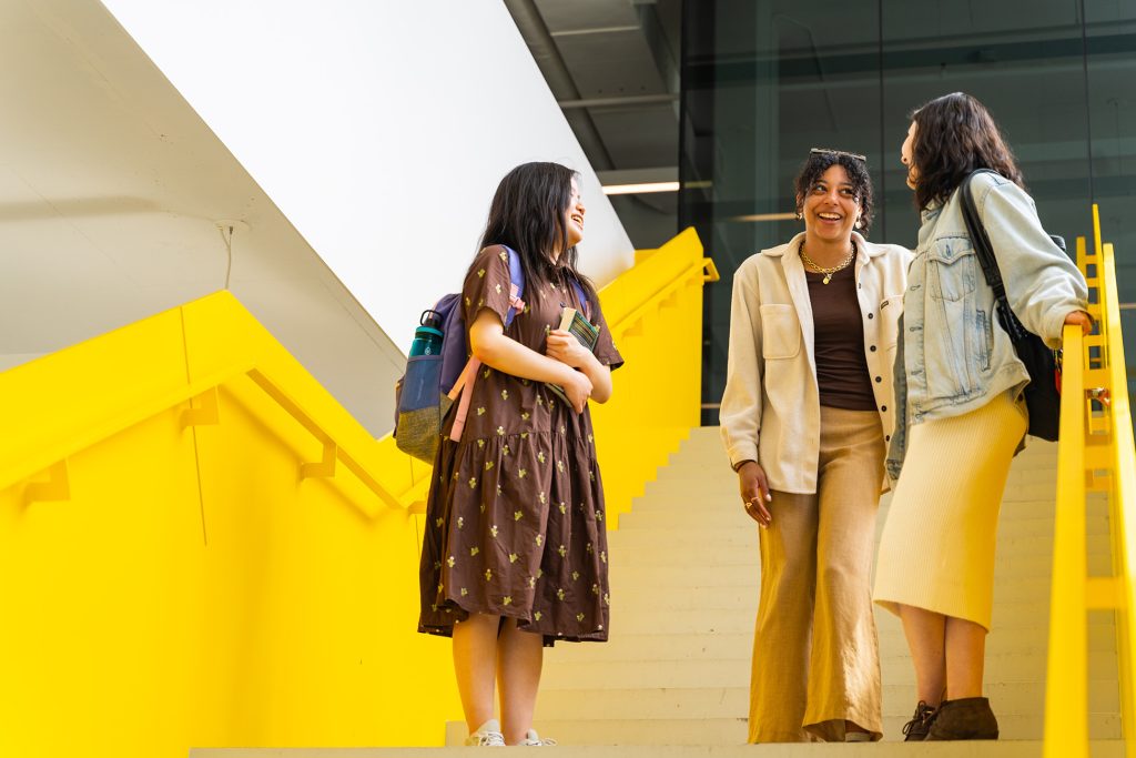 Three students chatting on the stairs.