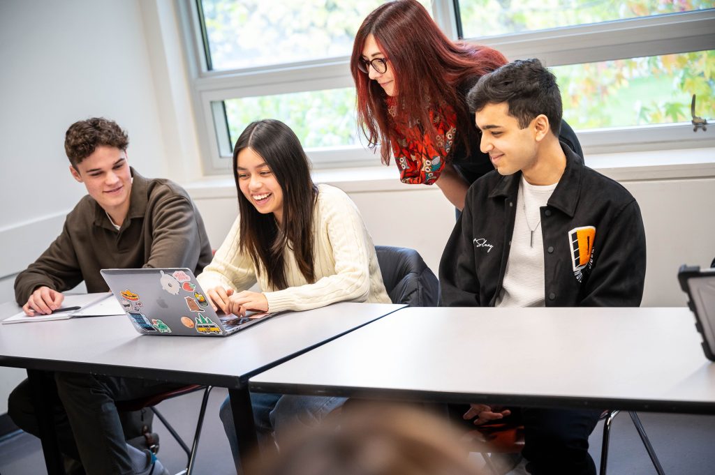 An instructor assists a group of students.